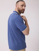 Remera azul con cuello polo y mangas cortas con ribete blanco.