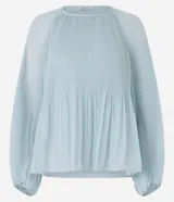 Blusa de crepé en color verde agua claro, con cuello redondo y mangas largas voluminosas. Presenta un diseño con textura plisada tanto en las mangas como en el cuerpo de la prenda, con puños ajustados.