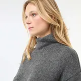 Vestido corto de punto en color gris, con cuello alto y mangas largas, de corte recto y diseño minimalista.