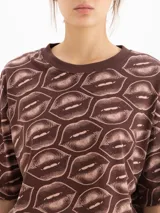 Remera marrón de manga corta y cuello redondo, con estampado all-over de labios.