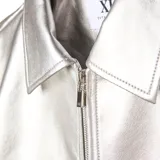 Campera de cuero sintético metalizado en color plateado, con cuello clásico, cierre frontal completo y bolsillos laterales.