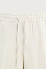 Pantalón regular fit color negro de tejido con viscosa, con cintura elástica ajustable con cordón, bolsillos frontales y traseros.