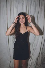 Vestido corto de color verde esmeralda, con escote en pico y breteles finos. Presenta aberturas en los laterales de la cintura y espalda descubierta.