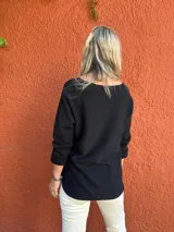 Sweater de tejido de punto color negro, con escote en V y mangas tres cuartos.