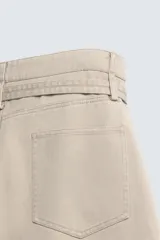 Pantalón de algodón color beige, estilo wide balloon fit, con cintura ajustable mediante cinturón de la misma tela. Presenta bolsillos frontales y bolsillos traseros de plastrón, con efecto lavado y abertura en el bajo.