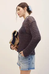 Sweater de punto calado color gris oscuro, de manga larga y diseño holgado.
