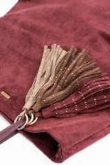 Charm para bolso compuesto por flecos de cuero sintético color marrón, decorados con pequeñas tachas metálicas doradas. Incluye un aro y un cierre de mosquetón metálico en tono dorado.