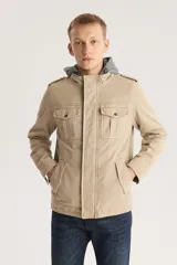 Campera color beige con capucha gris, cierre frontal con cremallera y botones a presión, cuatro bolsillos frontales con solapa y charreteras en los hombros.