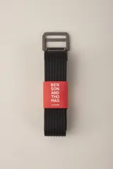 Cinturón de tela color beige con rayas verticales negras y hebilla metálica plateada con doble pasador.