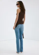 Jeans de corte recto y tiro medio, confeccionados en denim de algodón con un toque de elastano. Presentan un acabado clásico en tono azul claro con bajo desflecado.