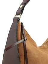 Cartera de hombro con diseño ovalado, confeccionada en cuero gamuza color camel con detalles en cuero napa. Presenta cierre en el acceso principal, logo metálico de la marca en la parte inferior y correa ajustable.