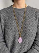 Collar con cadena dorada de eslabones y dije de resina en forma de gota de color celeste con efecto marmolado.