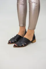 Sandalias de cuero negro con talón descubierto, tiras anchas entrecruzadas en el empeine y taco bajo de madera.