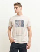 Remera color petróleo de manga corta con estampa de un edificio y texto en el frente.