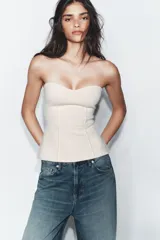 Top tipo corset de color negro con escote corazón y diseño strapless.