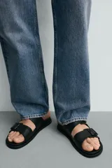 Sandalias negras de dos tiras anchas con hebillas ajustables y plantilla anatómica.