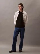 Remera de manga corta Calvin Klein Jeans con cuello redondo y corte regular. Confeccionada en algodón regenerativo con textura ligera tipo slub, presenta el logo de la marca estampado verticalmente en el pecho.