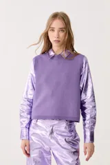 Chaleco de punto color lila con lurex, sin mangas y cuello redondo.