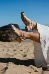 Sandalias doradas de cuero con tiras finas, taco bajo de madera y puntera cuadrada.