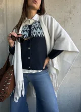 Cardigan de punto en color azul marino con diseño jacquard en tonos celestes y blancos en la parte superior. Presenta cuello redondo, cierre frontal con botones y mangas largas.