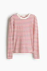 Remera de manga larga con cuello redondo y bajo recto, confeccionada en punto acanalado a rayas rojas y blancas.