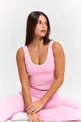 Conjunto deportivo compuesto por top de tirantes anchos con ribete blanco y pantalón tipo flare de tiro alto con cintura cruzada en V y detalle de ribete blanco.