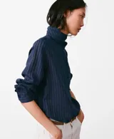 Blusa de manga larga color azul marino con sutiles rayas verticales, cuello alto drapeado y cierre frontal abotonado oculto.