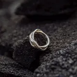 Anillo de diseño artesanal con estructura entrelazada de líneas irregulares y acabado orgánico. Pieza ajustable fabricada en metales nobles.