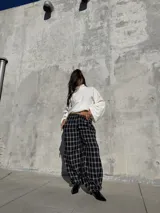 Pantalón de viyela con estampado de cuadrillé en blanco y negro. Presenta un diseño de silueta holgada con elástico en la cintura y en los puños, ofreciendo un estilo relajado y cómodo.