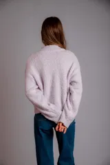 Buzo de punto color fucsia, con cuello redondo, manga larga y bordado de flores en amarillo y azul en el frente.