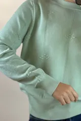 Buzo de hilo color verde menta, de cuello redondo y manga larga, con diseño de líneas verticales en relieve y pequeños detalles bordados.