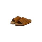 Sandalias Birkenstock modelo Zurich estilo mules, confeccionadas en gamuza color tostado con dos tiras anchas ajustables mediante hebillas metálicas, plantilla anatómica de corcho y suela de goma.