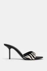 Sandalia de tacón alto fino, estilo mule, con tira delantera estampada con motivo de cebra en piel con pelo y acabado en punta redonda.
