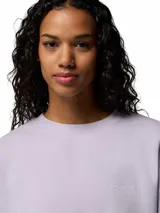 Buzo de cuello redondo color lila, con corte holgado y diseño minimalista. Presenta puños y dobladillo acanalados, con un pequeño logo bordado en el pecho.