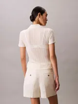 Chomba de manga corta Calvin Klein confeccionada en tejido de punto pointelle texturizado con mezcla de modal elástico. Presenta cuello tipo Johnny abierto y ribetes en punto canalé.