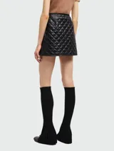 Minifalda negra acolchada con diseño de rombos.