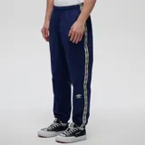 Pantalón de jogging azul marino con cintura y puños elásticos, bandas laterales estampadas con el logo de Umbro y sutil logo bordado en la pierna izquierda.