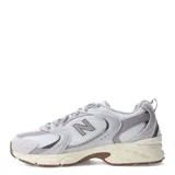 Championes New Balance modelo 530, con diseño retro-deportivo. Presentan una capellada de malla blanca transpirable con refuerzos sintéticos en tonos gris claro y lila. Incorporan entresuela con tecnología ABZORB para amortiguación y suela de goma en color marrón.