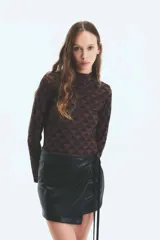 Polera marrón con estampado geométrico de triángulos y monogramas. De cuello alto y mangas largas.