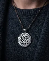 Collar con dije redondo de acero plateado con diseño de nudo celta entrelazado en el centro y alfabeto rúnico vikingo en el borde.