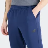 Pantalón de entrenamiento New Balance modelo Tenacity, color azul marino. Confeccionado en tejido de punto doble con tecnología NB DRY de secado rápido. Presenta un ajuste deportivo estilizado de tiro medio y diseño aerodinámico inspirado en el fútbol.