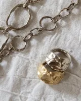 Anillo ancho de alpaca color plateado, con diseño irregular y textura rugosa. Pieza hecha a mano.