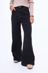Jean de corte wide leg en color negro, con tiro alto y diseño de cinco bolsillos.