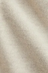 Top de punto fino con cuello redondo, hombros caídos y mangas al codo. Presenta costuras decorativas verticales en el frente y un bajo levemente acampanado con corte holgado.