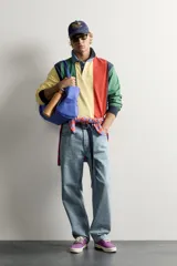 Polo de manga larga con diseño de rayas verticales anchas en colores amarillo, verde, rojo, azul marino y celeste. Cuenta con cuello camisero de denim y cierre frontal parcial con botones ocultos bajo solapa.