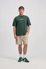 Remera oversize de manga corta color marrón con estampa pequeña en el pecho y estampa geométrica en la espalda.