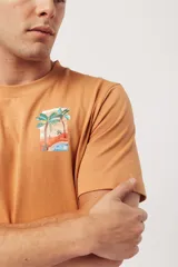 Remera blanca de algodón con cuello redondo y manga corta. Estampado frontal con una ola azul, un sol naranja y el texto "SURF UNTIL SUNSET".