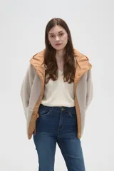 Campera de poliéster color tostado con capucha, cierre frontal con botones a presión y bolsillos delanteros amplios. El interior está forrado con corderito para mayor abrigo.