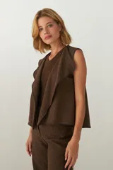 Chaleco color beige con textura tipo espiga, corte holgado y solapa cruzada.