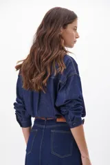 Camisa de jean celeste con botones metálicos envejecidos, manga larga y bolsillo en el pecho.